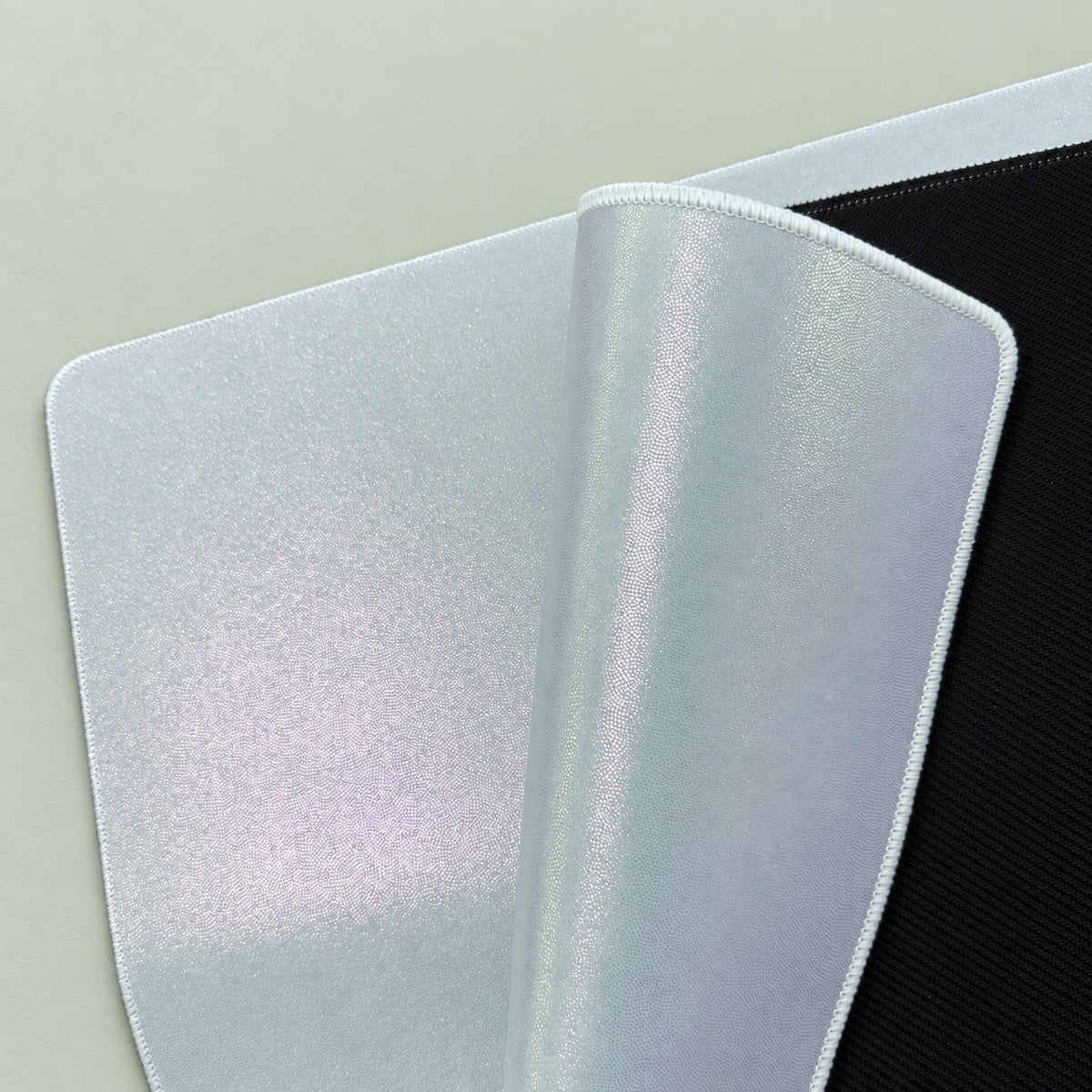 Blank sublimation playmat corner curled back to show flexible 1.5 mm rubber and black non-slip underside