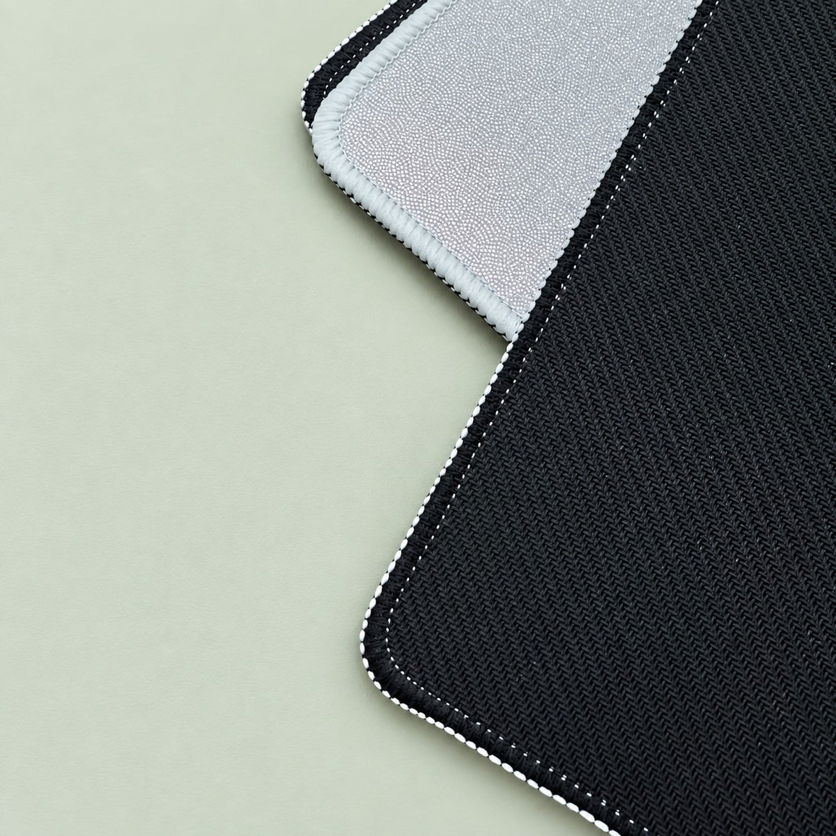 Black non-slip textured rubber backing of a blank holofoil TCG playmat